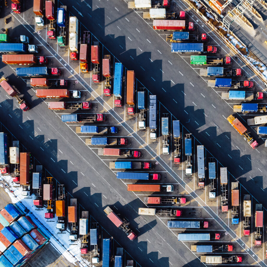 Rows of Trucks Driving in Harbor with Trailers