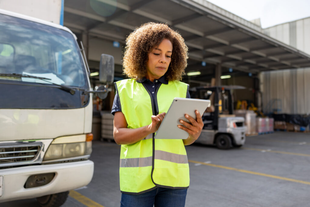 Woman supervising the dispatch of trucks at a distribution warehouse