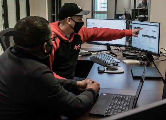 Two WTC Group employees sitting in front of computers to ensure we're providing efficient, high-quality freight forwarding services to our clients.