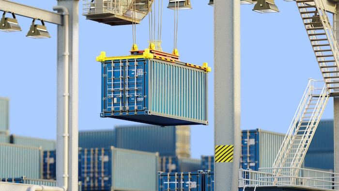 Port logistics operations, Cargo handling. Crane lifts shipping container at container terminal for loading, unloading, and intermodal freight transportation.