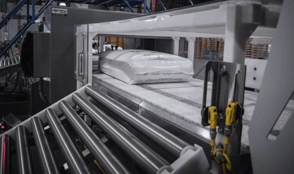 Sealed bag of plastic resin or polymer material passing through a metal detection system on an industrial conveyor line